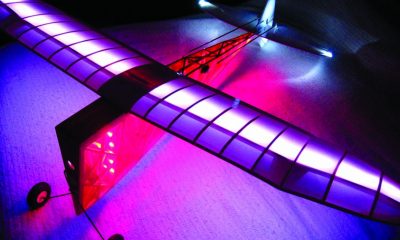 This scratch-built balsa plane is the Wedgy, featured in Model Airplane News November, 1940. The V-shaped fuselage is covered with transparent red and has solid white strip LEDs shining downward. The wing is white on the top and clear on the bottom. It has programmable LEDs shining upward in the wing.